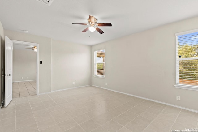 tiled spare room featuring ceiling fan