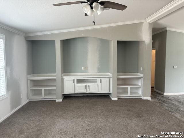 unfurnished living room featuring a wealth of natural light, ceiling fan, dark carpet, and ornamental molding