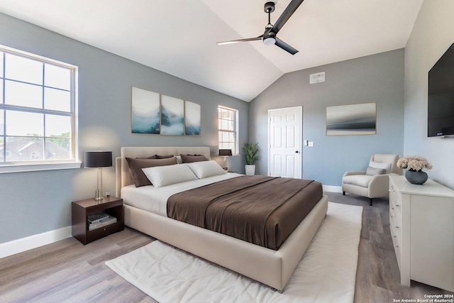 bedroom with ceiling fan, light hardwood / wood-style floors, and multiple windows