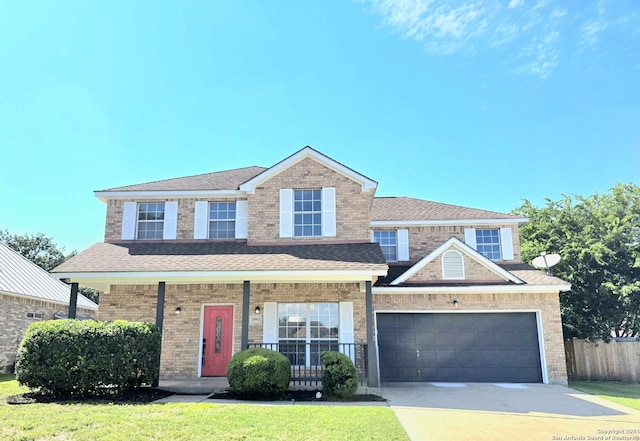 view of front of home featuring a garage, a front yard, and a porch