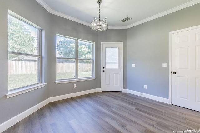 interior space with an inviting chandelier, ornamental molding, and hardwood / wood-style floors