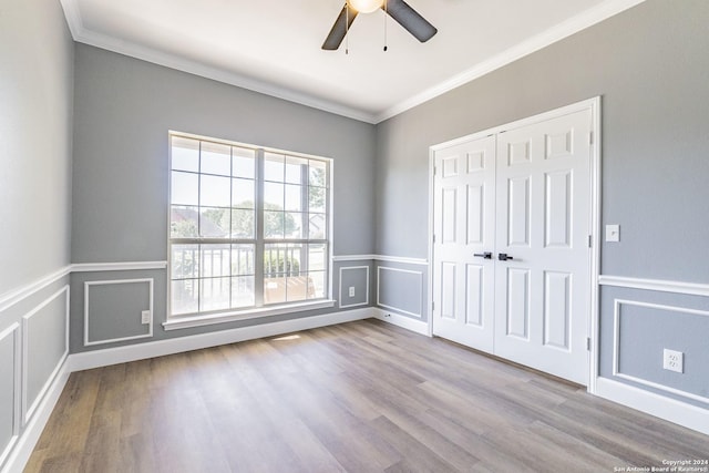 empty room with ceiling fan, ornamental molding, and light hardwood / wood-style flooring