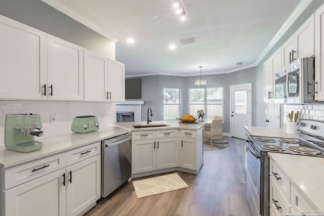 kitchen featuring sink, white cabinetry, appliances with stainless steel finishes, and hanging light fixtures