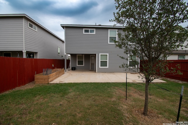 rear view of house with a lawn and a patio