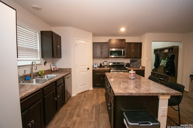 kitchen featuring stainless steel appliances, hardwood / wood-style floors, sink, and a kitchen island