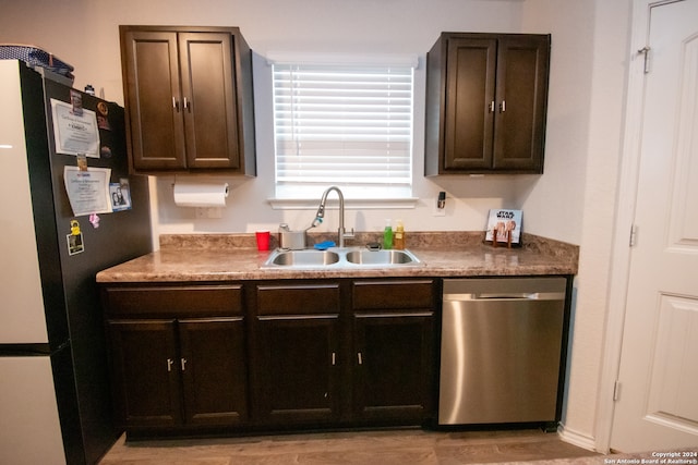 kitchen featuring sink, dishwasher, dark brown cabinetry, and fridge