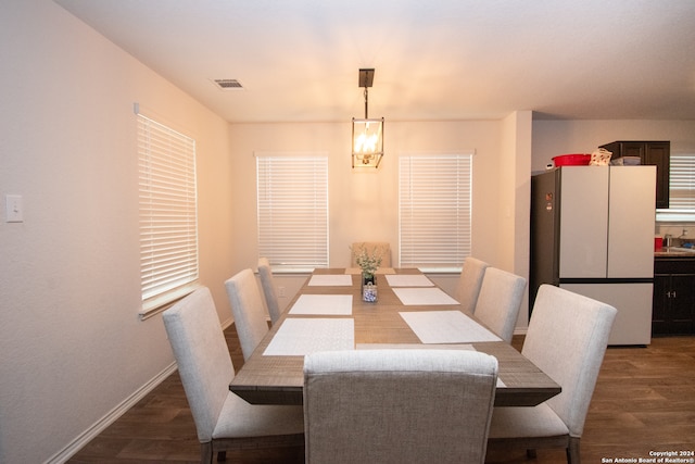 dining area with dark hardwood / wood-style floors and a chandelier