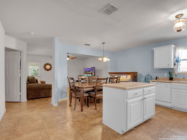 kitchen with white dishwasher, a center island, pendant lighting, and white cabinets