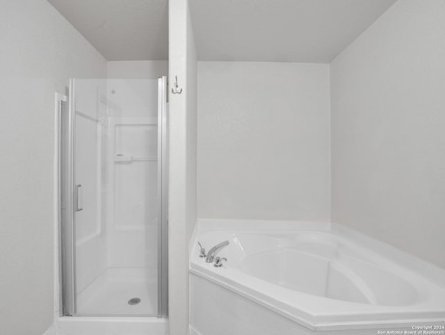 bathroom with a shower with door and a textured ceiling