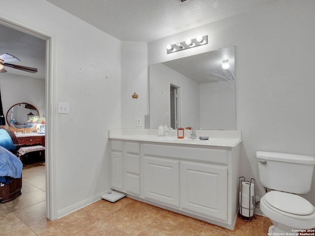 bathroom with ceiling fan, tile patterned floors, a textured ceiling, toilet, and vanity