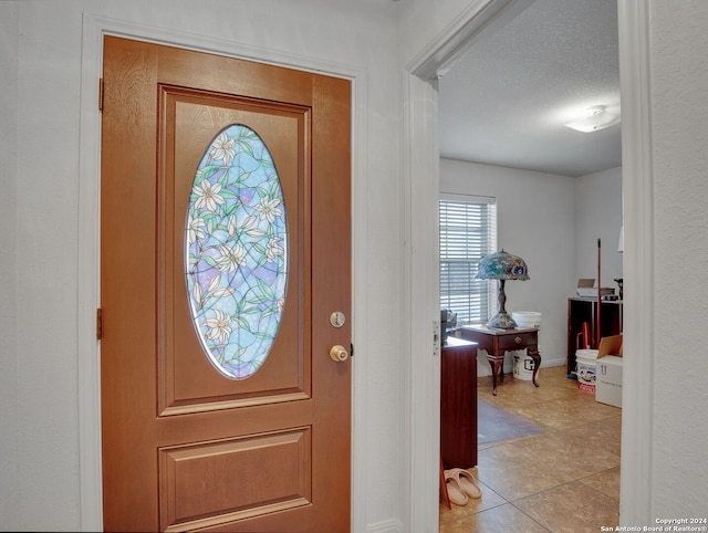 tiled foyer with a textured ceiling