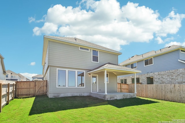 rear view of house featuring a yard and a patio area