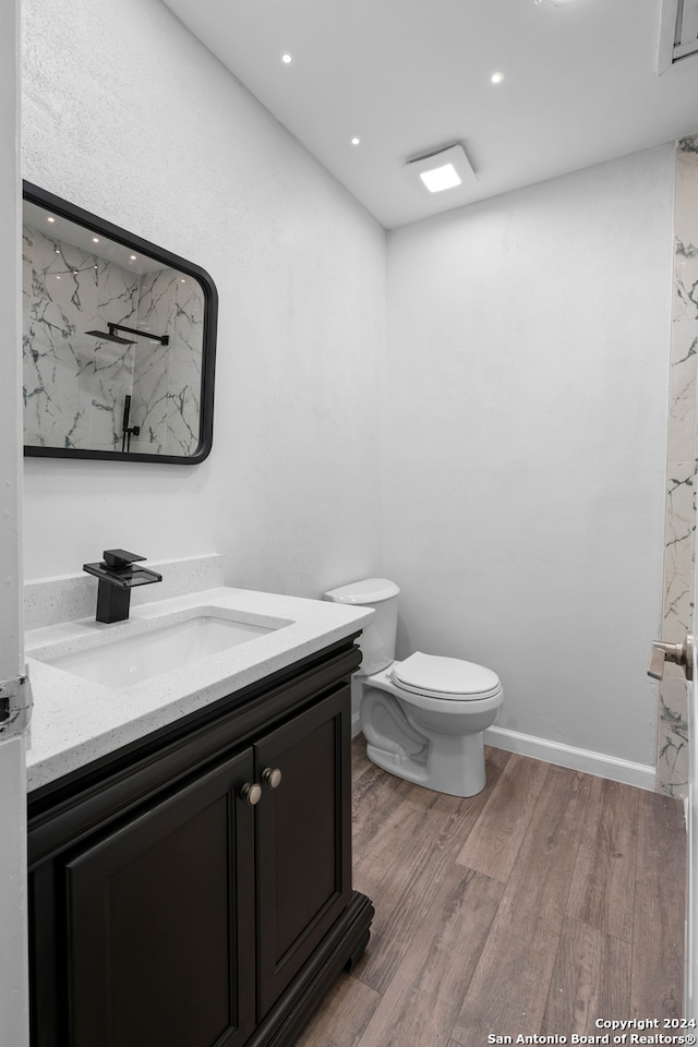 bathroom featuring vanity, toilet, and hardwood / wood-style floors