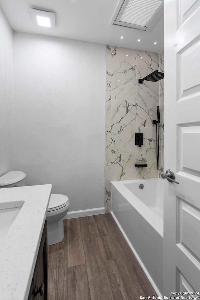 full bathroom featuring tiled shower / bath, vanity, toilet, and wood-type flooring