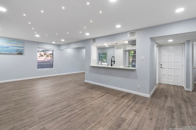 interior space featuring white cabinets, sink, hardwood / wood-style flooring, and kitchen peninsula