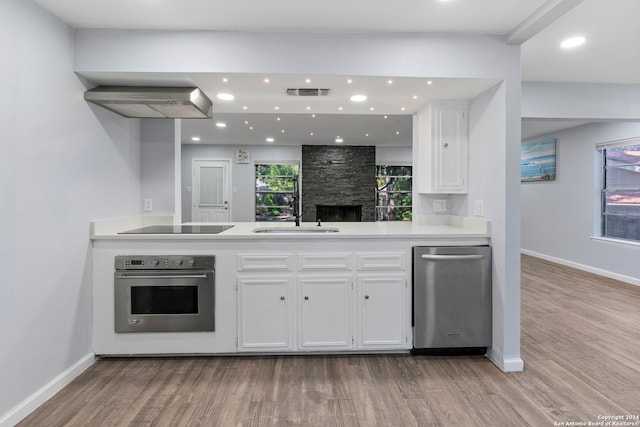 kitchen featuring appliances with stainless steel finishes, sink, white cabinets, and light hardwood / wood-style flooring