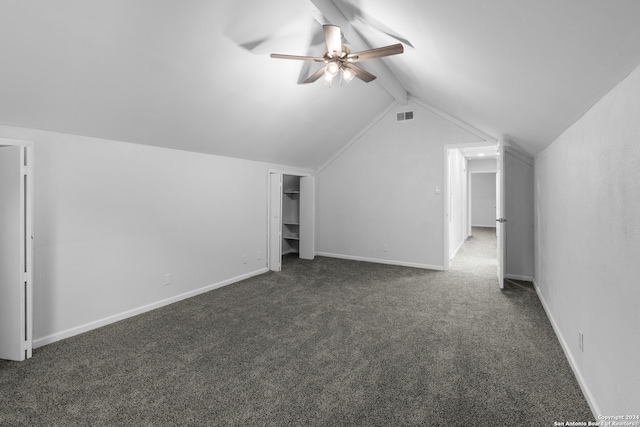 additional living space with ceiling fan, lofted ceiling with beams, and dark carpet