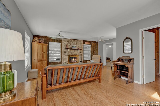 living room featuring ceiling fan, light hardwood / wood-style floors, and a fireplace