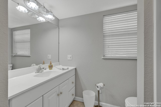 bathroom featuring vanity with extensive cabinet space, toilet, and tile floors