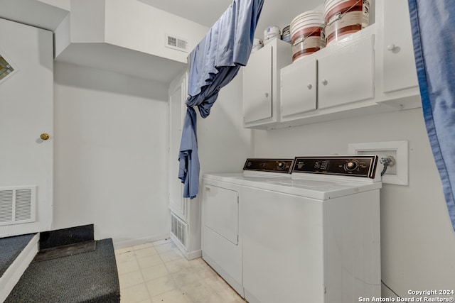 clothes washing area featuring hookup for a washing machine, cabinets, light tile floors, and washing machine and clothes dryer