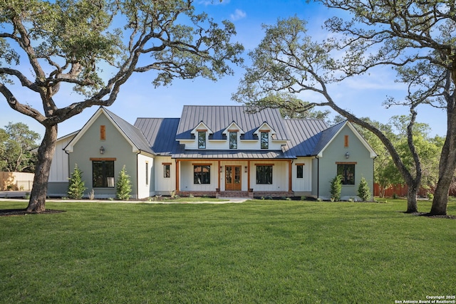 modern inspired farmhouse featuring a standing seam roof, a front lawn, metal roof, and board and batten siding
