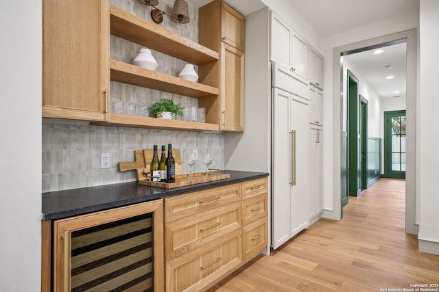 indoor dry bar with wine cooler, light wood-style floors, decorative backsplash, paneled built in fridge, and recessed lighting