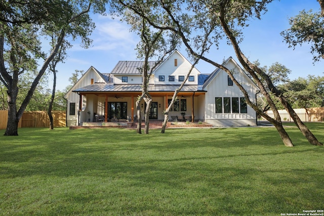rear view of property featuring ceiling fan, a standing seam roof, board and batten siding, and metal roof