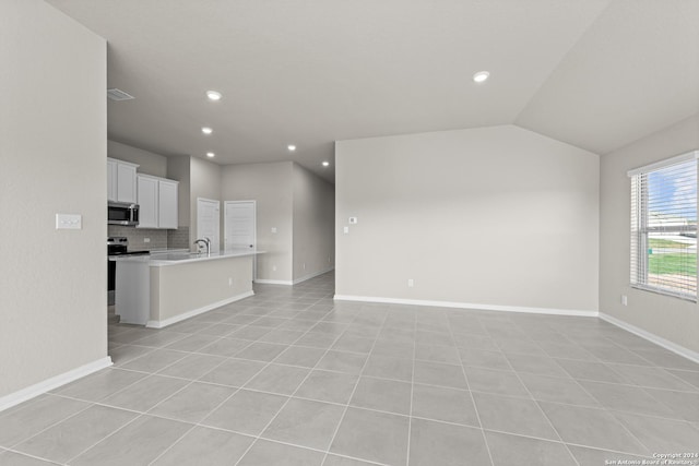 unfurnished living room featuring light tile patterned flooring and vaulted ceiling