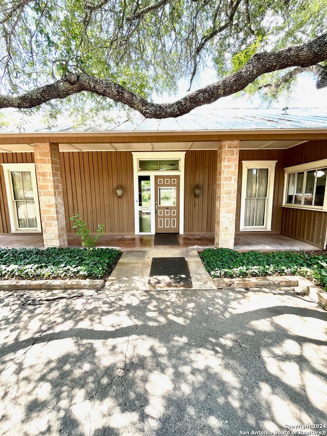 view of exterior entry with a porch