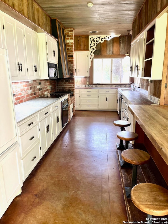 kitchen featuring butcher block counters, white cabinets, backsplash, oven, and wood ceiling