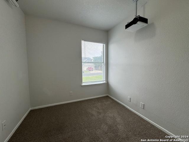 carpeted spare room with a textured ceiling