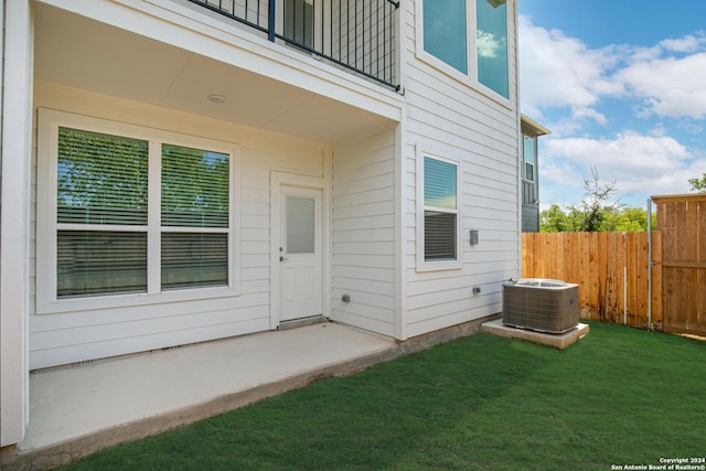 doorway to property featuring central AC, a yard, and a balcony