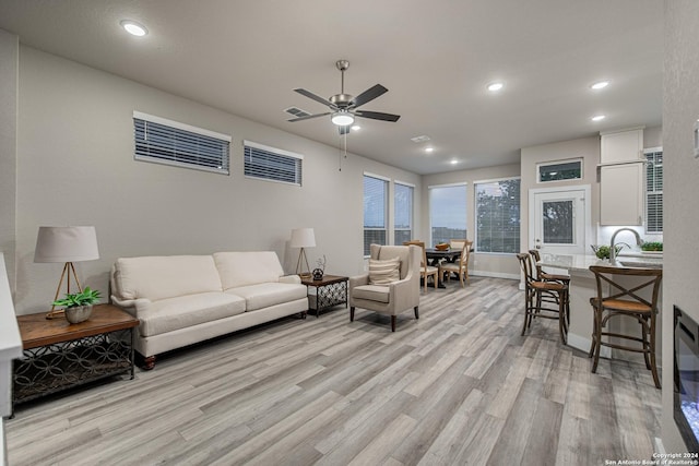 living room featuring ceiling fan and light wood-type flooring