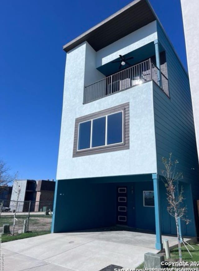 view of front of home with a balcony and ceiling fan