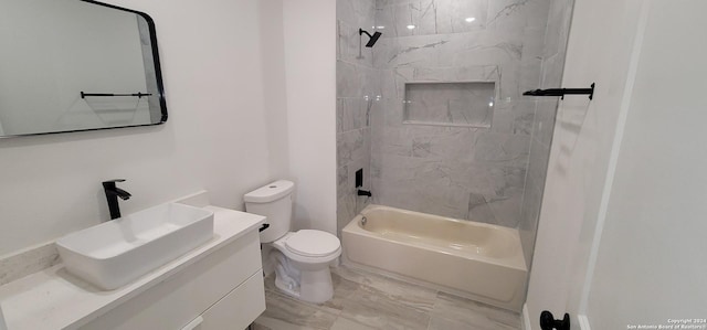 full bathroom with toilet, vanity, and tiled shower / bath