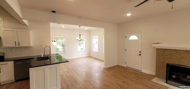 kitchen with white cabinets, pendant lighting, stainless steel dishwasher, and sink