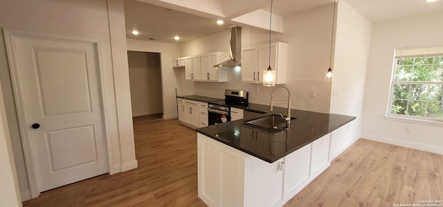 kitchen featuring white cabinetry, sink, wall chimney exhaust hood, kitchen peninsula, and stainless steel electric range