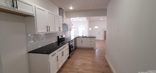 kitchen with decorative backsplash, sink, electric range, light hardwood / wood-style floors, and white cabinetry