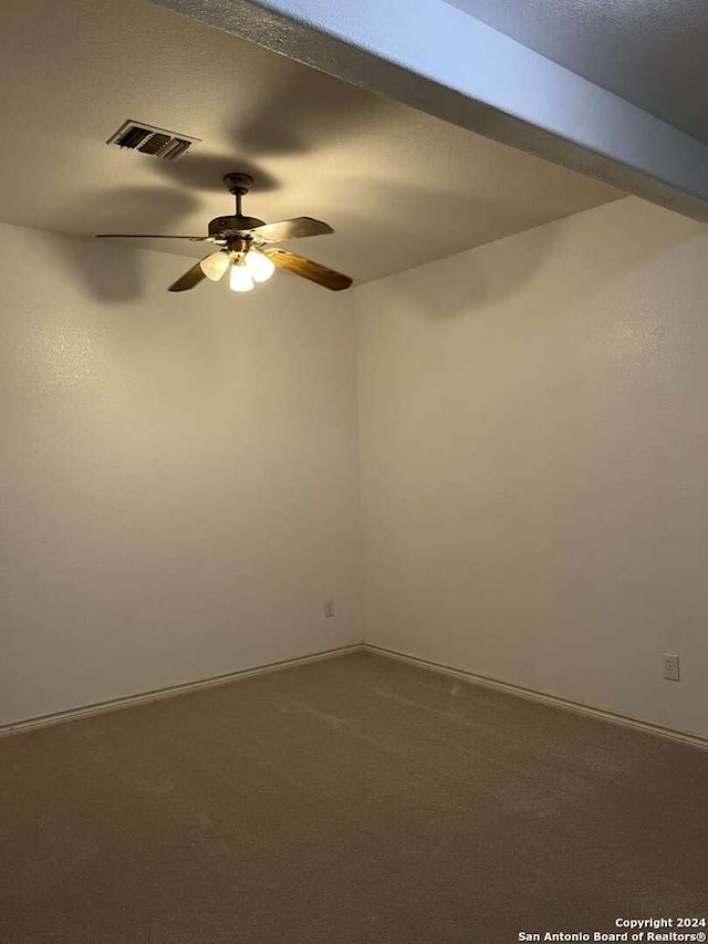 unfurnished room with carpet flooring, beamed ceiling, a textured ceiling, and ceiling fan