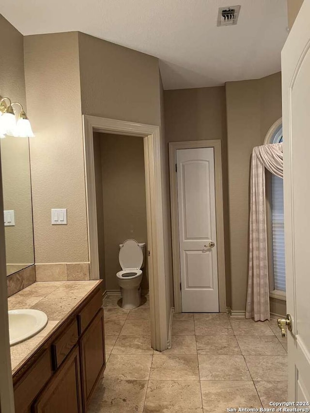 bathroom with vanity, tile patterned floors, and toilet