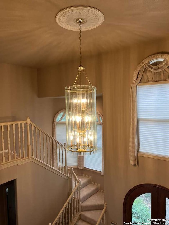 staircase with a high ceiling and a chandelier