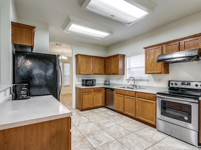 kitchen featuring black appliances, sink, light tile patterned floors, a notable chandelier, and extractor fan