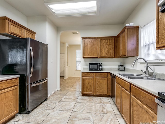 kitchen with range, refrigerator, plenty of natural light, and sink