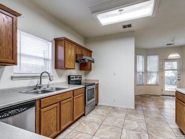 kitchen featuring exhaust hood, sink, hanging light fixtures, light tile patterned floors, and stainless steel appliances