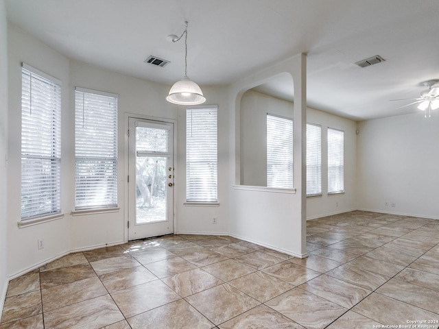 unfurnished dining area with ceiling fan and a healthy amount of sunlight