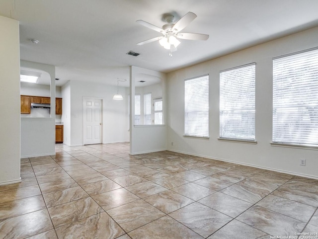 empty room featuring ceiling fan and a healthy amount of sunlight