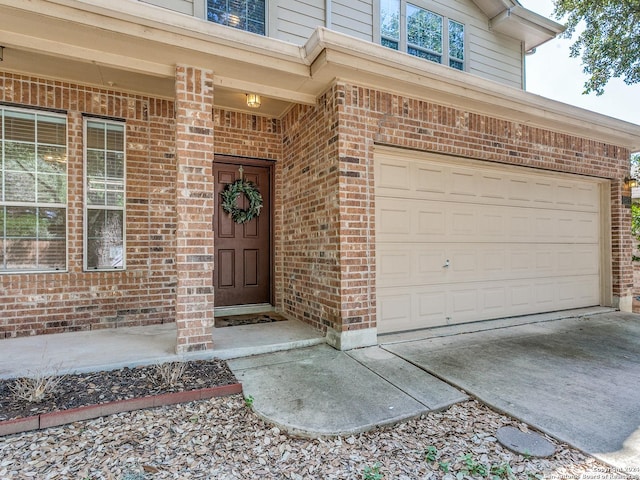 view of exterior entry featuring a porch and a garage