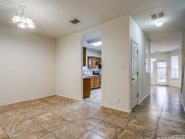 interior space with light tile patterned flooring, an inviting chandelier, and sink