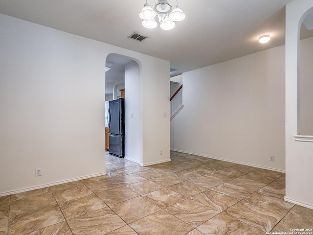 spare room featuring a notable chandelier