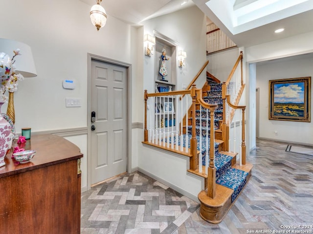 foyer with a skylight and light parquet floors